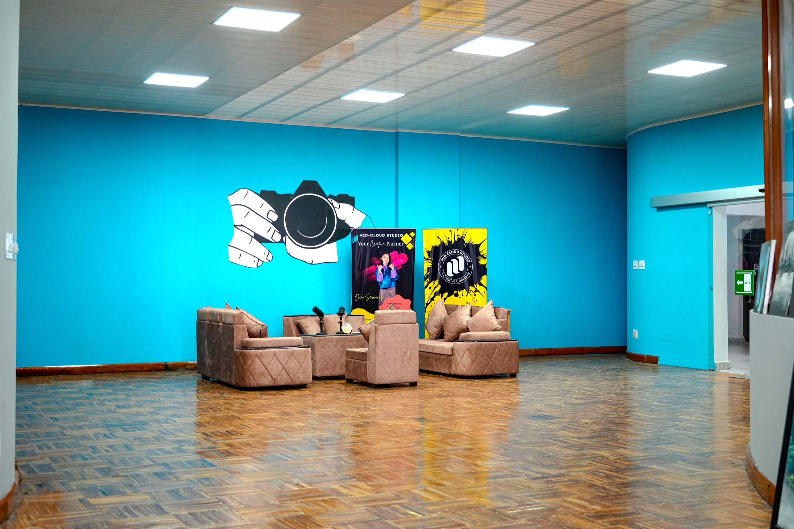 Mid-Cloud Studio interior with turquoise walls, camera artwork, and a recording lounge